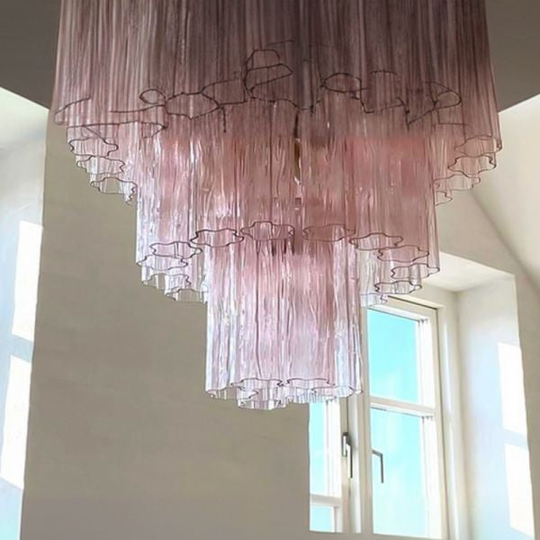 Large pink murano glass chandelier suspended over contemporary dining table