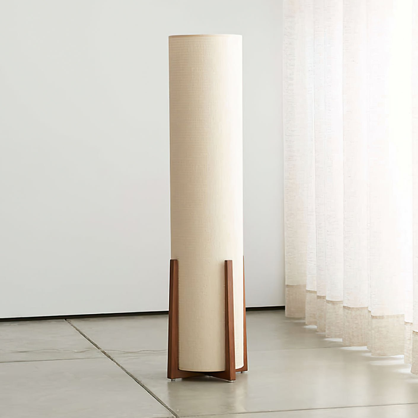 Modern floor lamp with woven fabric shade beside minimalist furniture