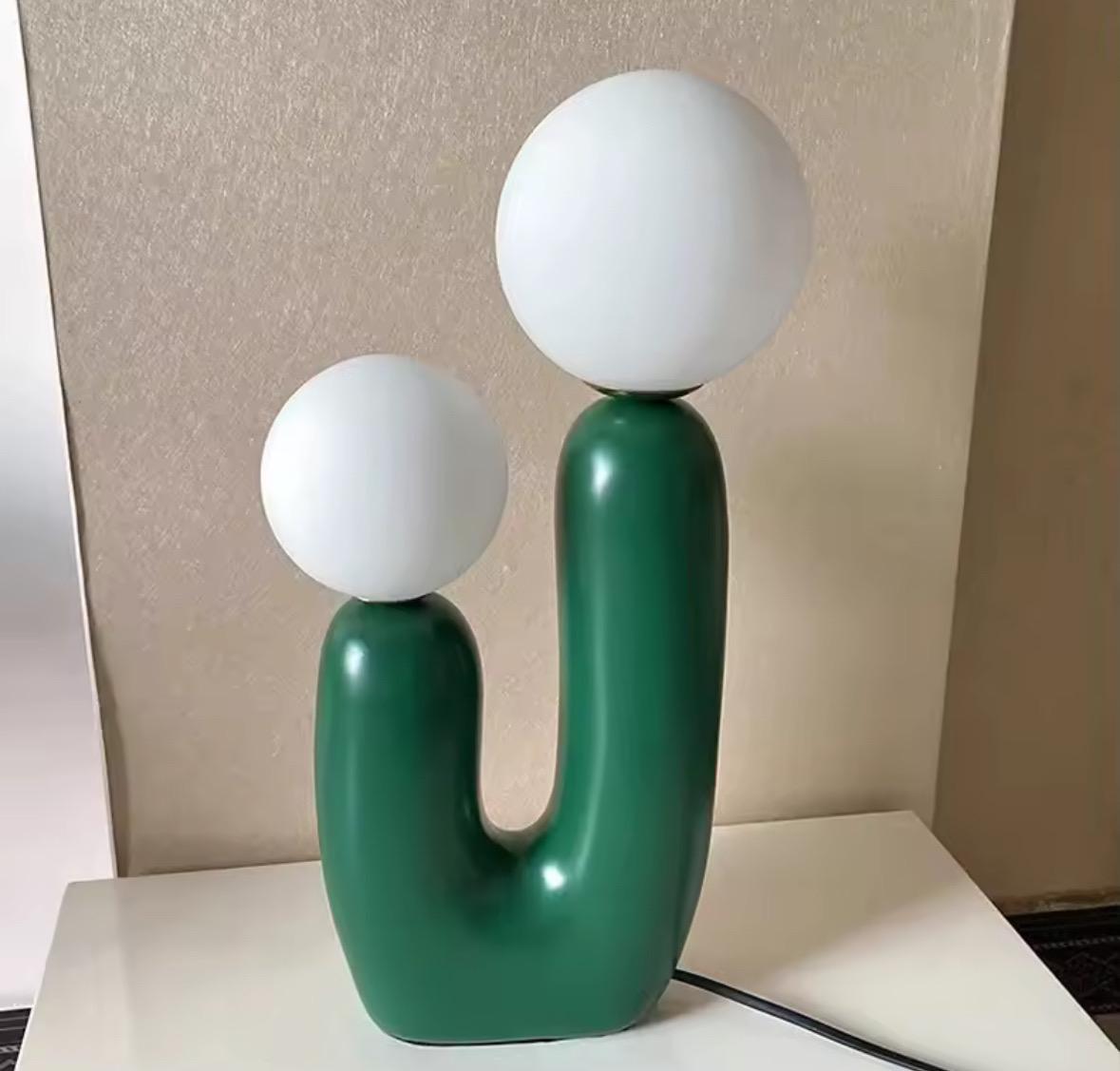 Mid century inspired ceramic lamp in green colorway with ambient lighting