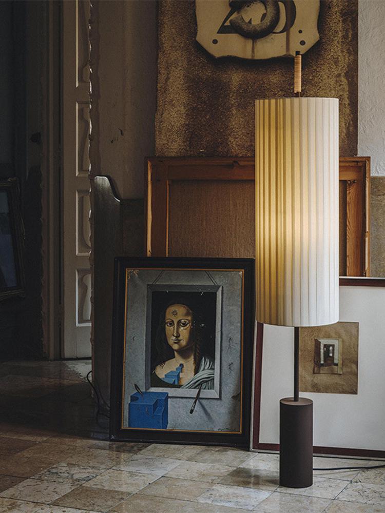 Minimalist cylindrical floor lamp with sculptural metal structure