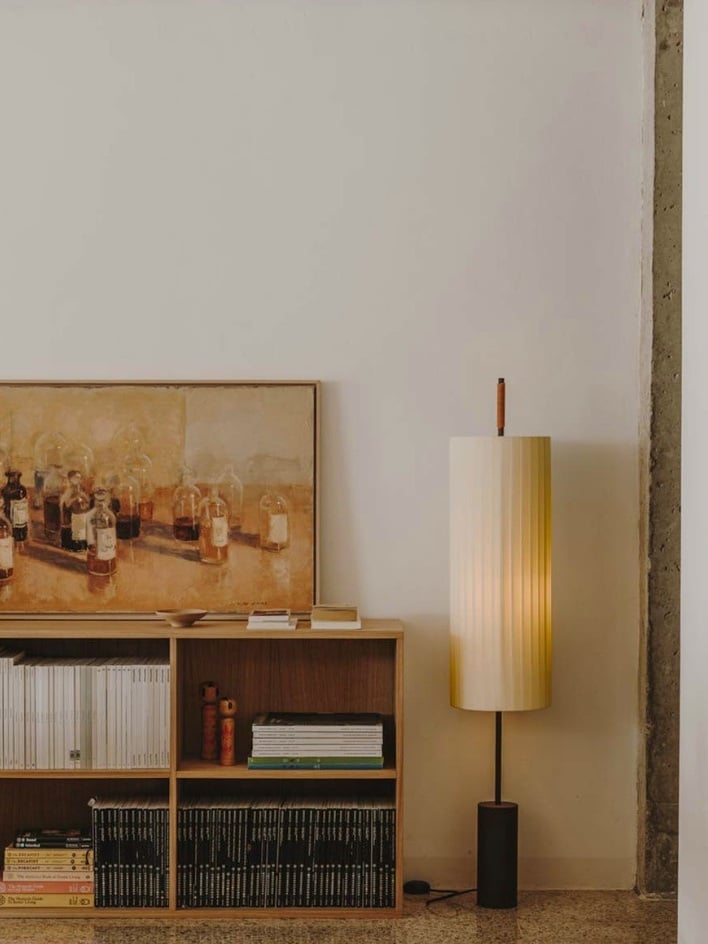 Designer fabric shade floor lamp casting warm light in reading corner